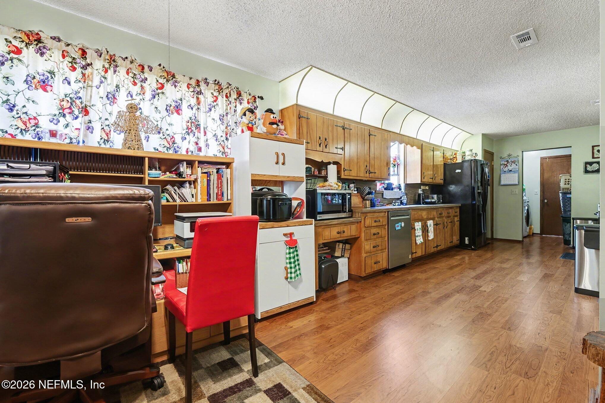 2551 Ridgecrest Avenue Orange Park, FL 32065 - Photo 5 of 28 a view of a kitchen with stainless steel appliances kitchen island granite countertop a refrigerator and microwave