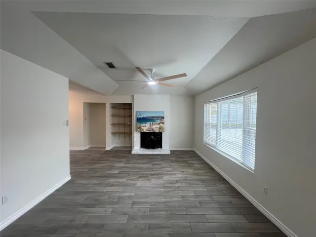 an empty room with windows fireplace and windows
