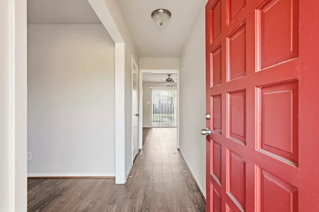 a view of a hallway with wooden floor and staircase
