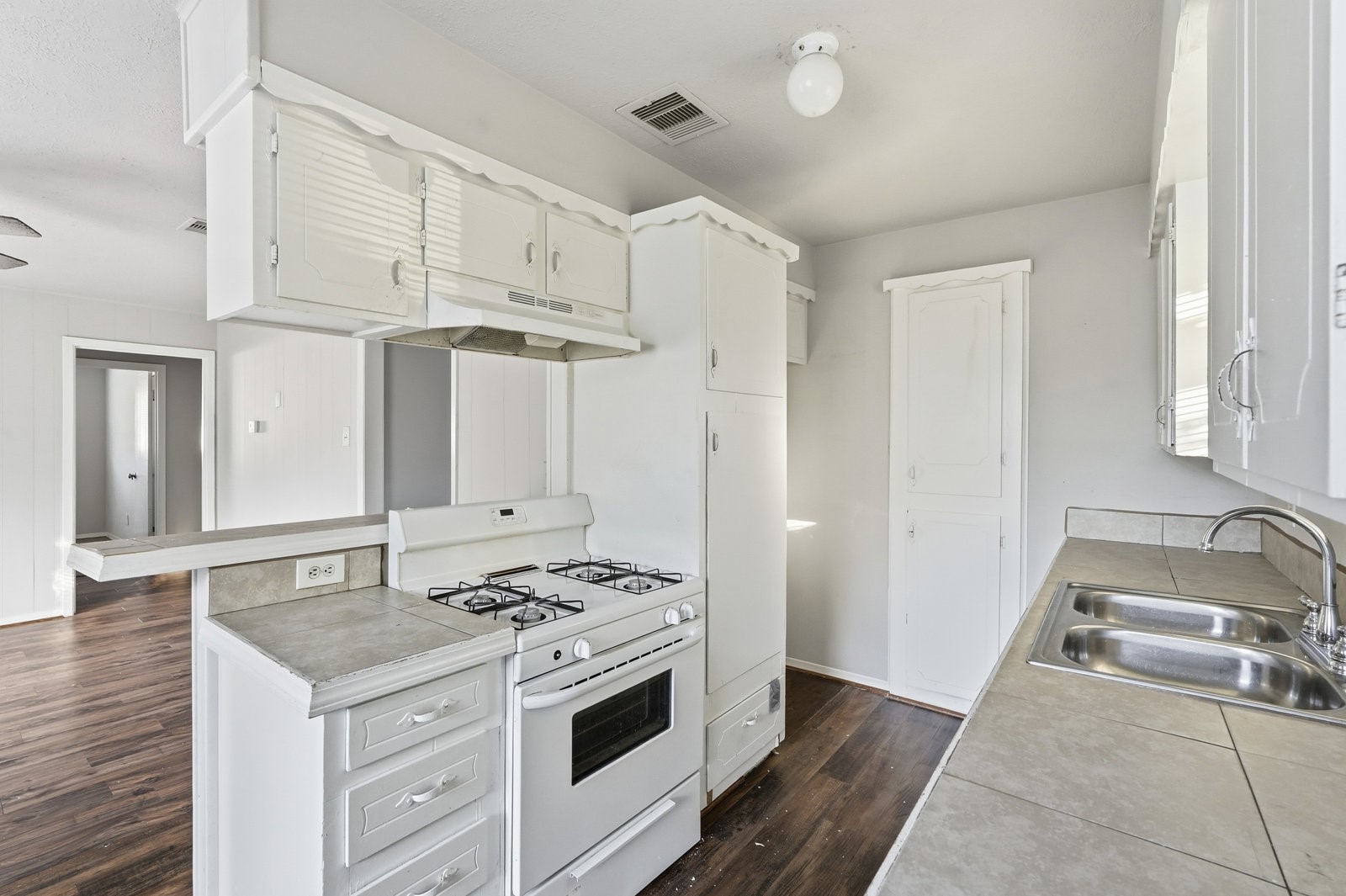 3427 Prudence Drive Houston, TX 77045 - Photo 9 of 25 a kitchen with granite countertop a sink a stove and a wooden floors