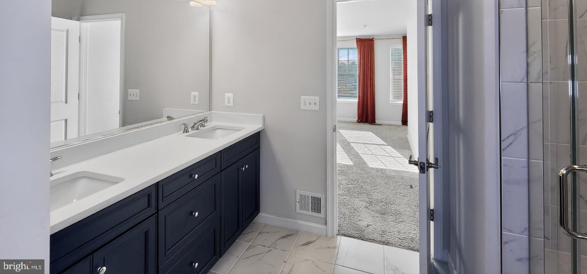 10570 Sally Ride Lane Lanham, MD 20706 - Photo 24 of 32 a bathroom with a double vanity sink and a mirror