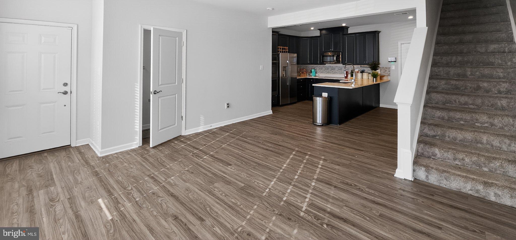 10570 Sally Ride Lane Lanham, MD 20706 - Photo 6 of 32 a view of living room kitchen with stainless steel appliances wooden floor and view living room