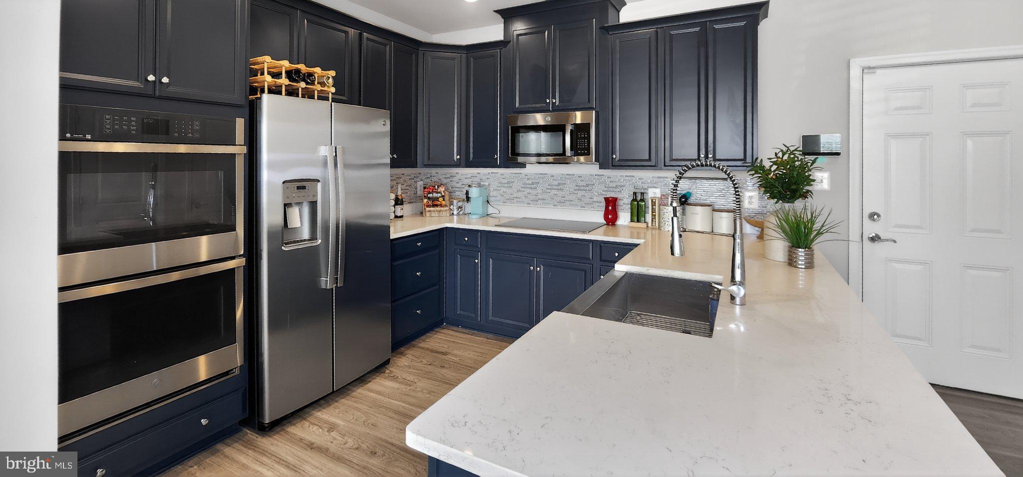 10570 Sally Ride Lane Lanham, MD 20706 - Photo 7 of 32 a kitchen with stainless steel appliances a refrigerator and a stove top oven