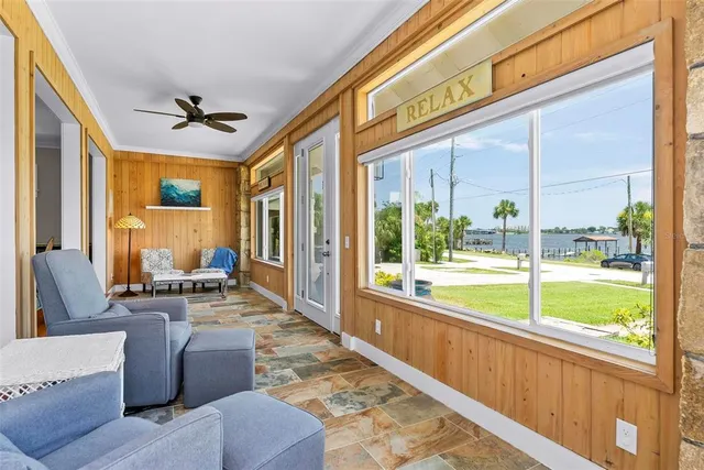 a view of a hallway with wooden floor and windows