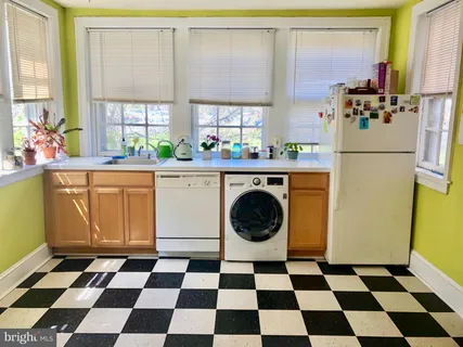 a kitchen with a stove a refrigerator a sink and a stove with wooden floor
