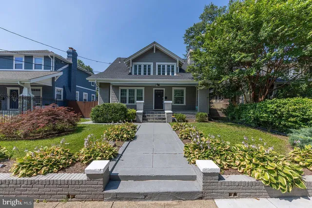 a front view of a house with a yard and potted plants