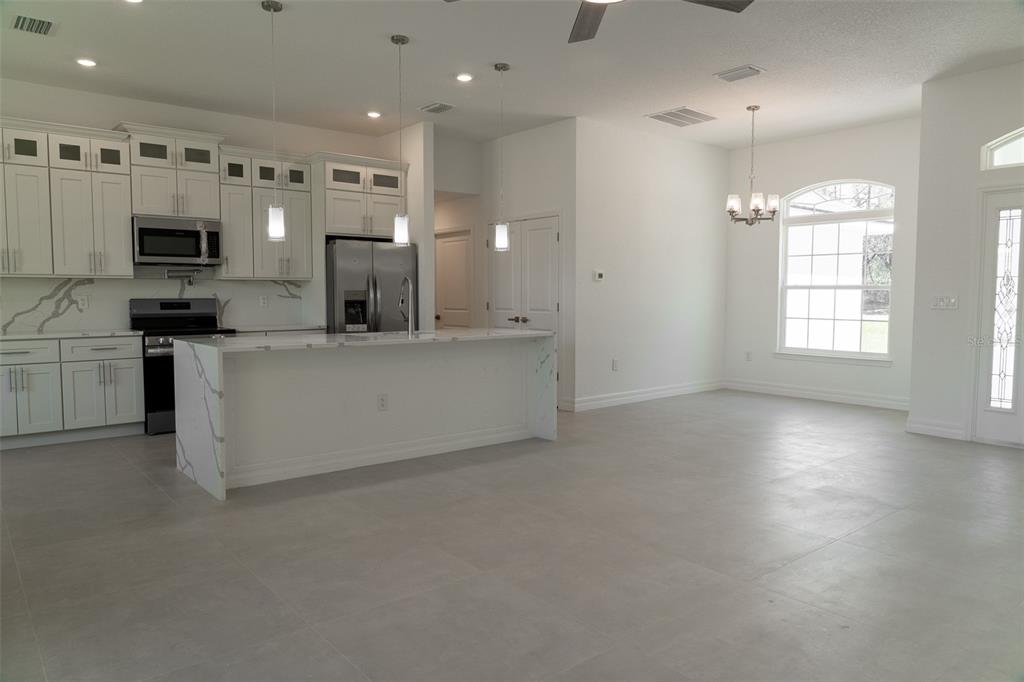 17820 Southwest 33rd Terrace Ocala, FL 34473 - Photo 11 of 35 a large kitchen with stainless steel appliances a large counter top and a stove top oven