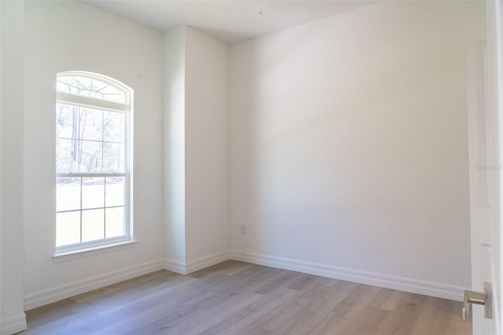 17820 Southwest 33rd Terrace Ocala, FL 34473 - Photo 12 of 35 an empty room with wooden floor and windows
