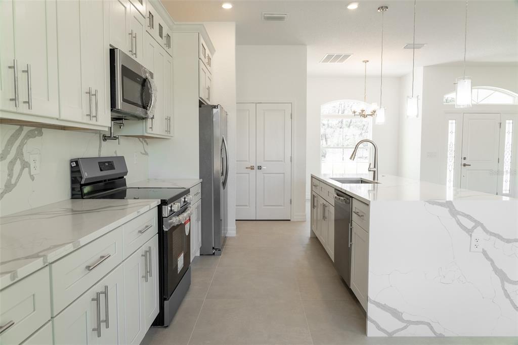 17820 Southwest 33rd Terrace Ocala, FL 34473 - Photo 25 of 35 a kitchen with white cabinets and stainless steel appliances