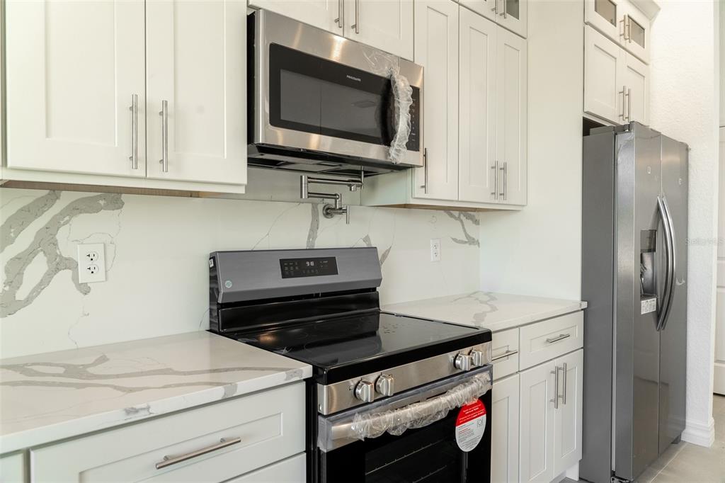 17820 Southwest 33rd Terrace Ocala, FL 34473 - Photo 26 of 35 a kitchen with stainless steel appliances white cabinets and a stove top oven
