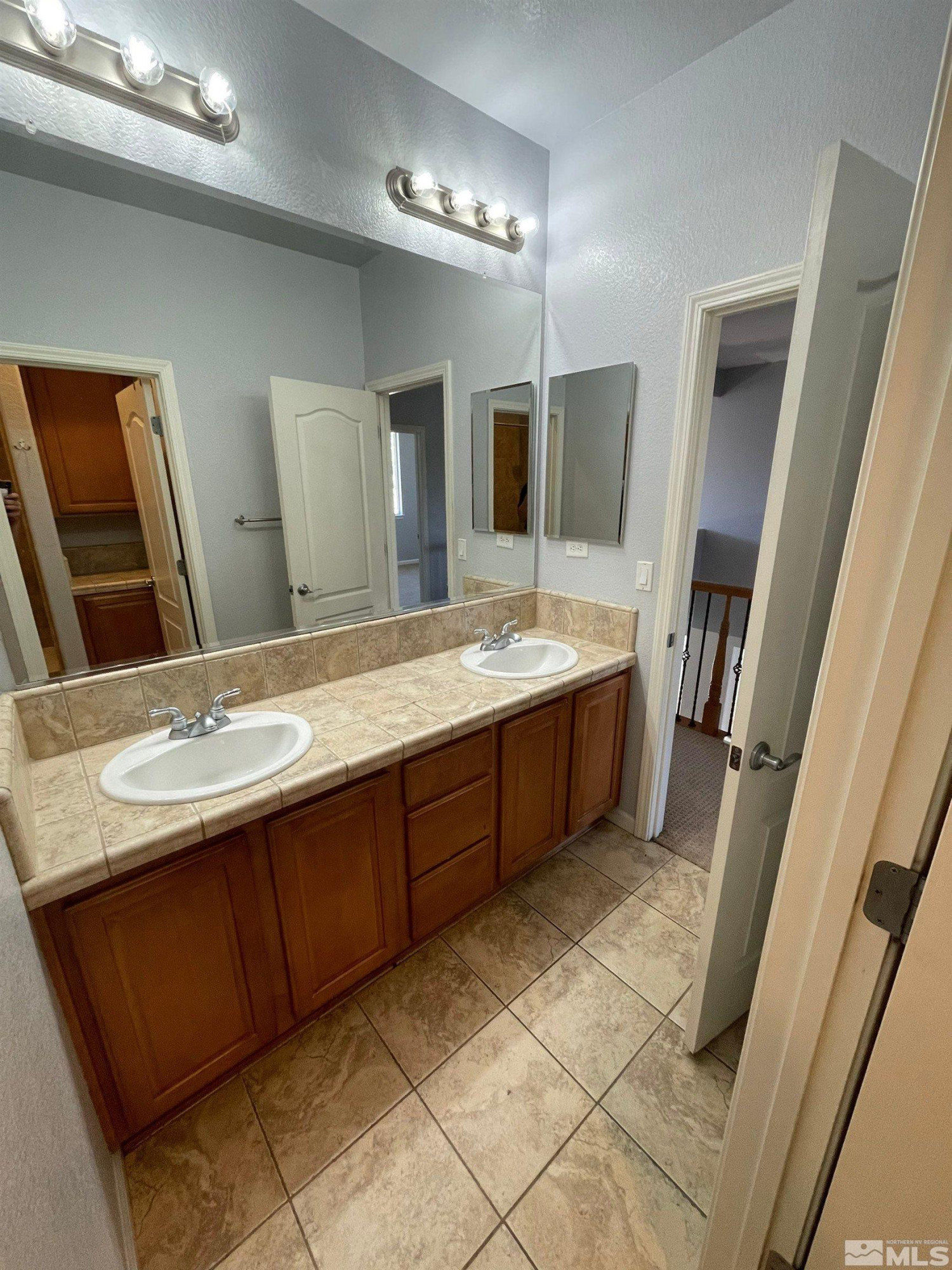 3660 Sienna Pointe Court Reno, NV 89512 - Photo 18 of 24 a bathroom with a double vanity sink a mirror and shower