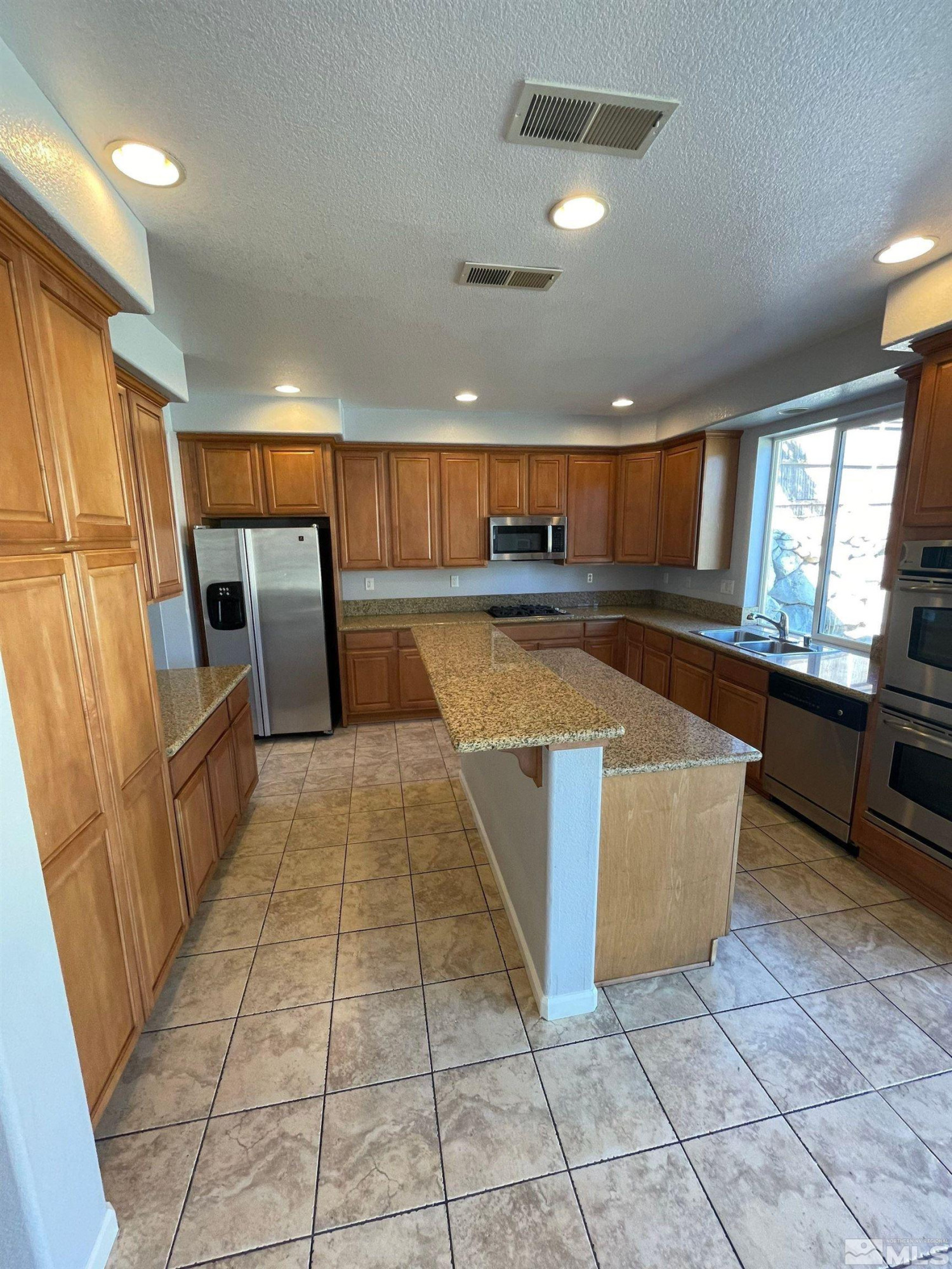 3660 Sienna Pointe Court Reno, NV 89512 - Photo 3 of 24 a large kitchen with cabinets and a stainless steel appliances