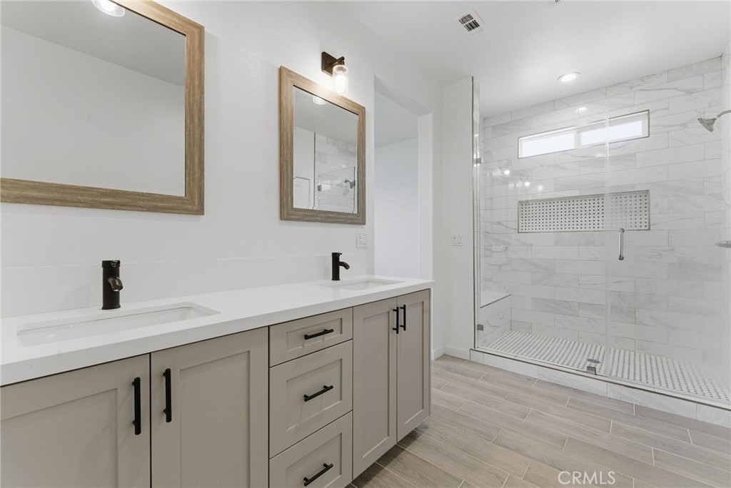 10710 Brookfield Drive Riverside, CA 92505 - Photo 17 of 32 a bathroom with a shower sink vanity and mirror
