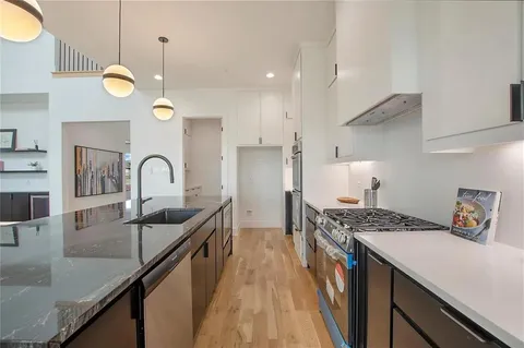 a kitchen with granite countertop a sink a stove and cabinets