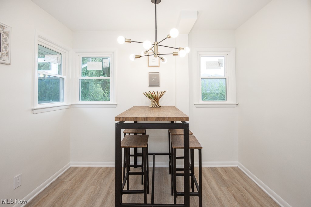 22210 Emery Road Cleveland, OH 44128 - Photo 14 of 32 Dining area with healthy amount of natural light, light lvt floors, and a chandelier