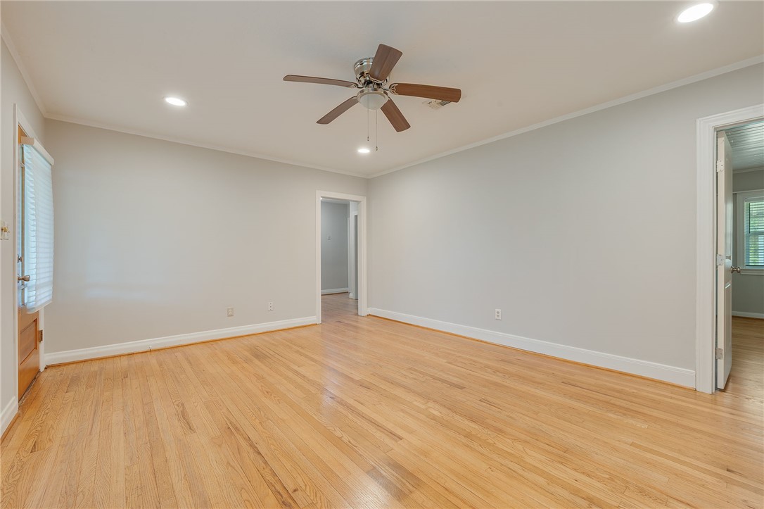 715 Inwood Drive Bryan, TX 77802 - Photo 5 of 34 wooden floor in an empty room with a ceiling fan