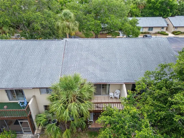 an aerial view of a house with a yard and large tree