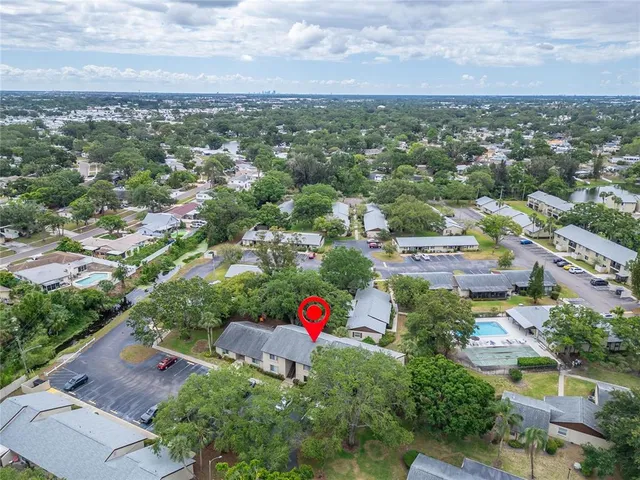 an aerial view of residential houses with outdoor space and trees