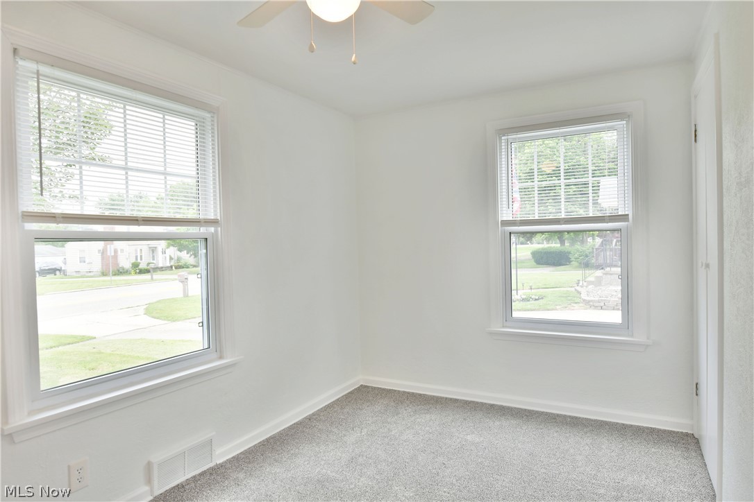 130 State Road Northwest Warren, OH 44483 - Photo 12 of 35 Carpeted spare room with a wealth of natural light and ceiling fan