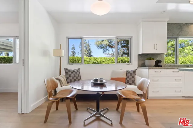 a view of a dining room with furniture a rug and wooden floor