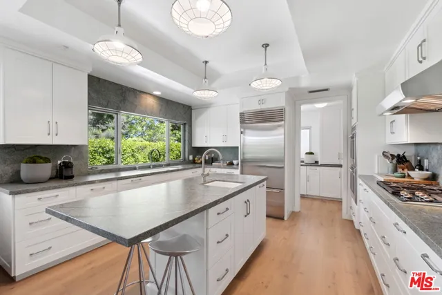 a kitchen with kitchen island a sink stove and refrigerator