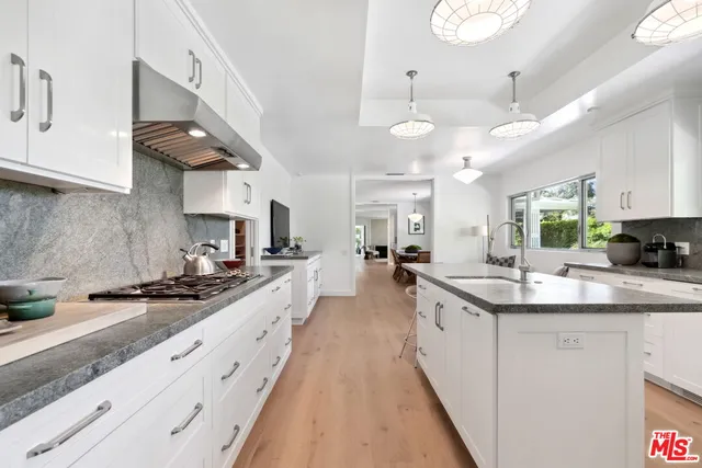 a large kitchen with stainless steel appliances lots of counter space and a sink