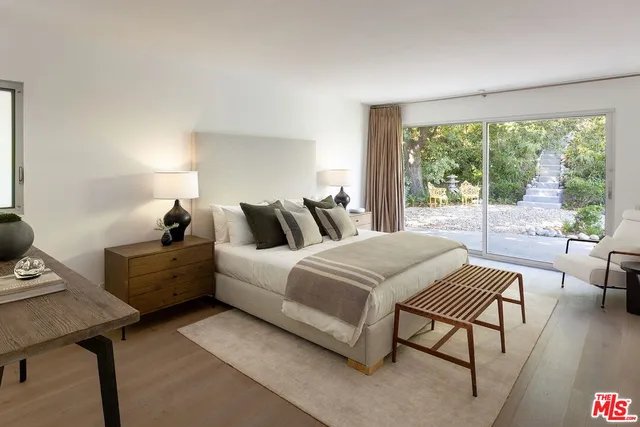 a spacious bedroom with a bed and a large window