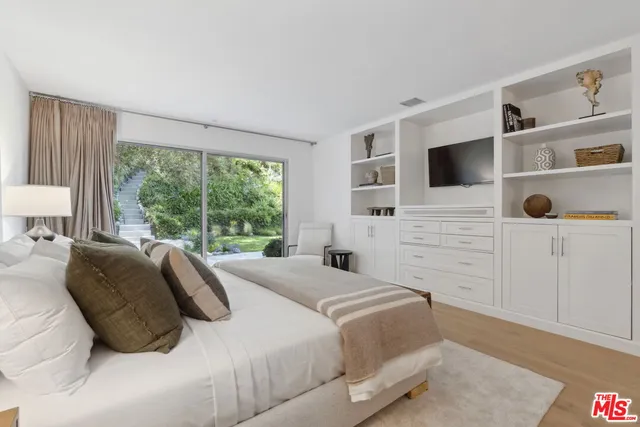 a bedroom with a bed and a flat tv screen