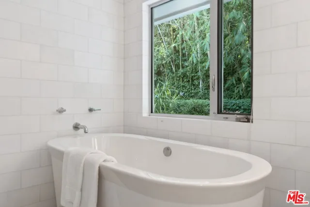 a white bath tub sitting in a bathroom next to a window