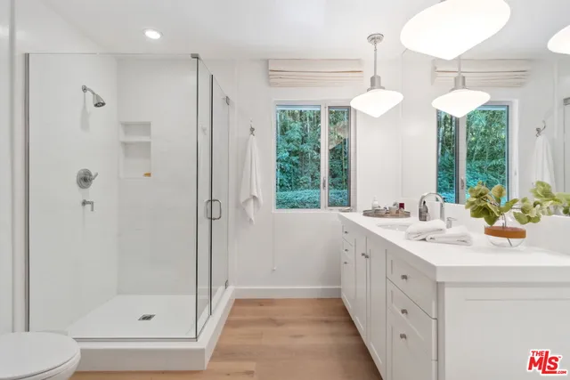 a bathroom with a double vanity sink mirror and shower