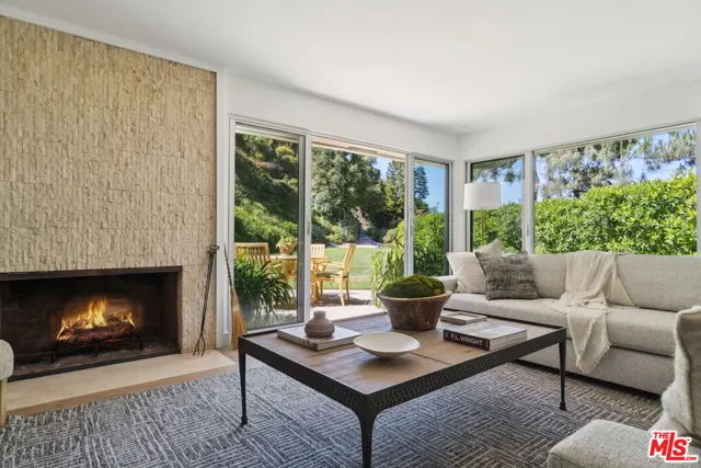 a living room with furniture a fireplace a large window and a fireplace