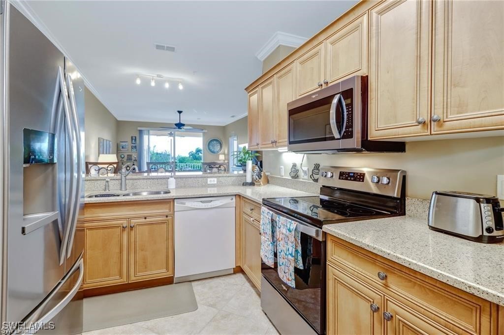 8261 Pathfinder Loop, Unit 745 Fort Myers, FL 33919 - Photo 7 of 22 a kitchen with stainless steel appliances granite countertop a stove microwave and sink