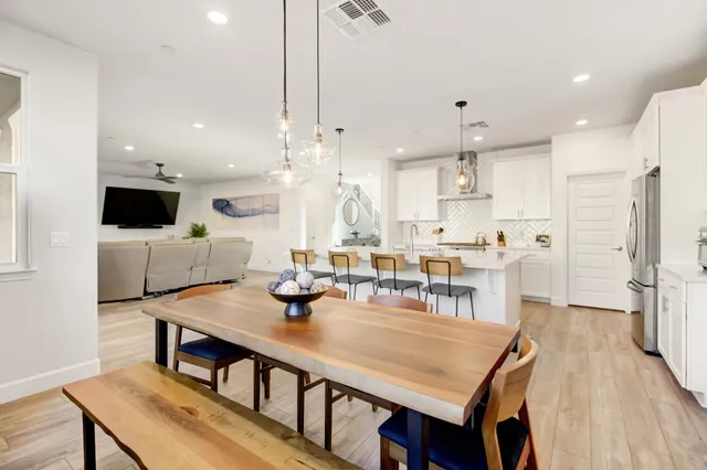 a bedroom with a bed a desk and chair with wooden floor