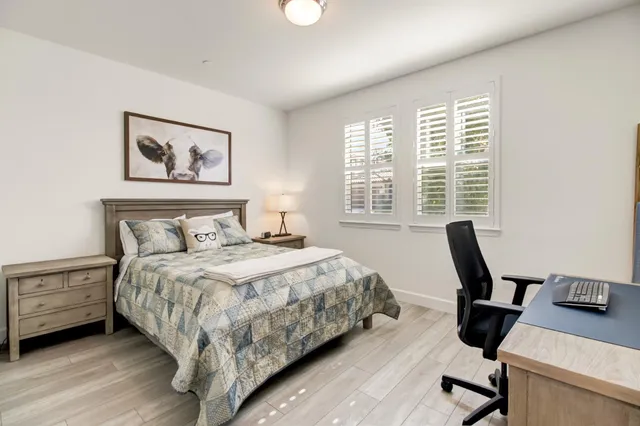 a bedroom with a large bed and a chandelier