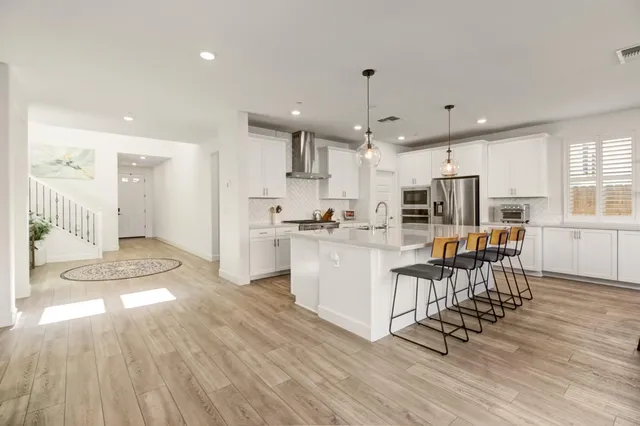 a kitchen with stainless steel appliances kitchen island granite countertop a sink and cabinets