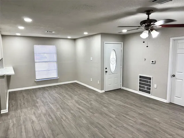 a view of empty room with wooden floor