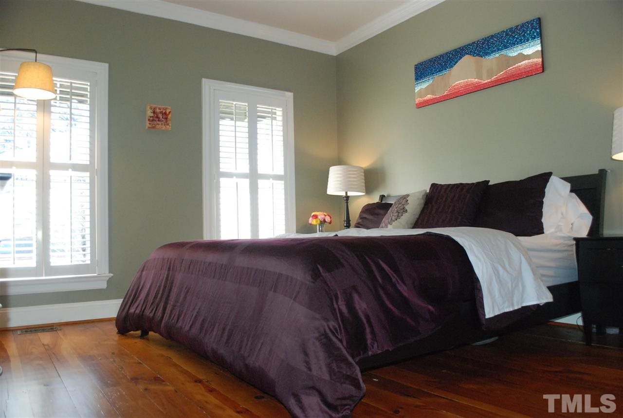 426 Morrison Avenue Raleigh, NC 27608 - Photo 15 of 25 a bedroom with a bed and wooden floor