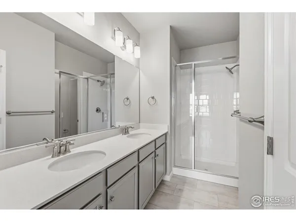 a bathroom with a sink double vanity granite tub shower and a mirror