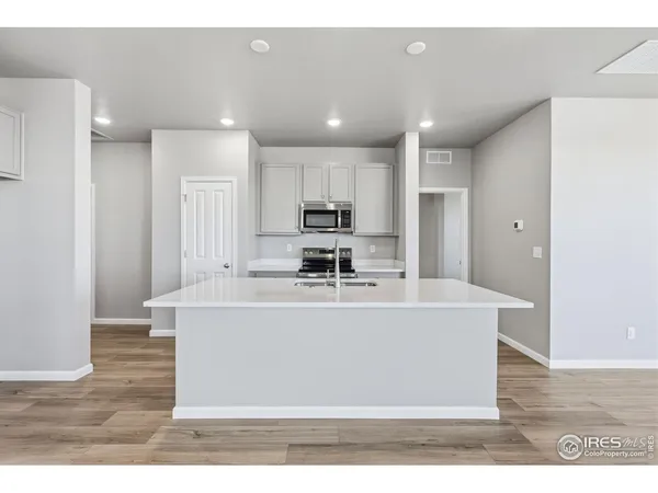 a view of kitchen with stainless steel appliances granite countertop a sink a stove and a refrigerator