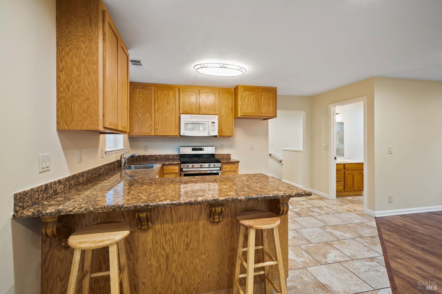 84 Front Street Camp Meeker, CA 95419 - Photo 7 of 24 a kitchen with a granite countertop sink table and chairs