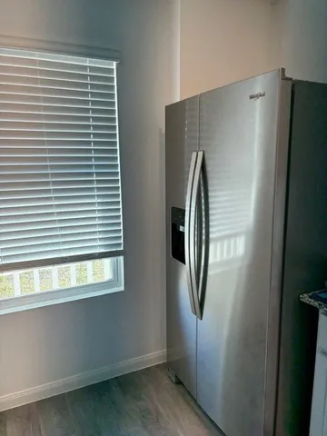 a view of a refrigerator in kitchen and a window