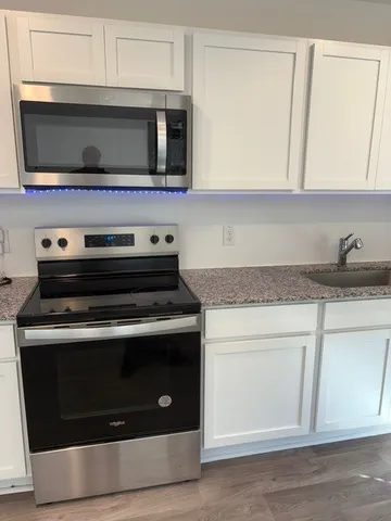 a kitchen with microwave stove and cabinets