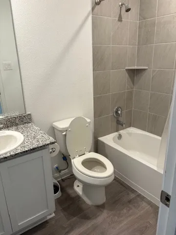 a bathroom with a granite countertop toilet a sink and bathtub