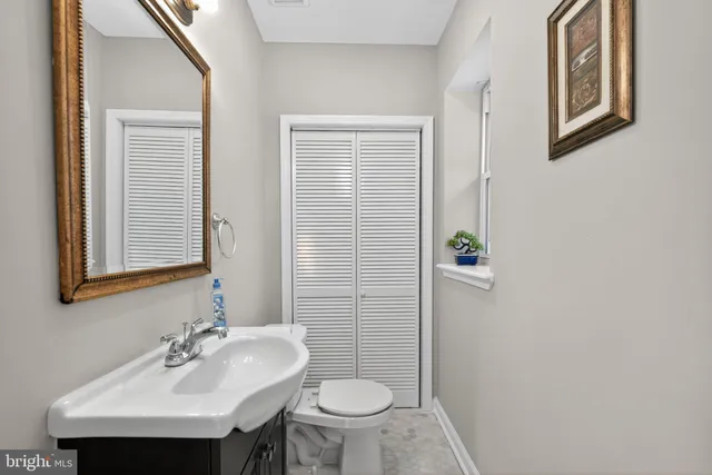 a bathroom with a sink toilet and a mirror