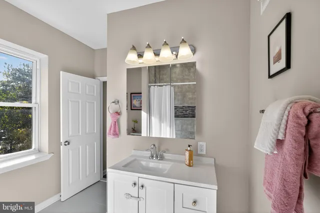 a bathroom with a sink vanity and a mirror