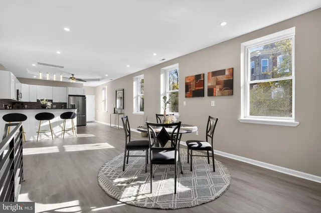 a dining room with furniture entryway and wooden floor