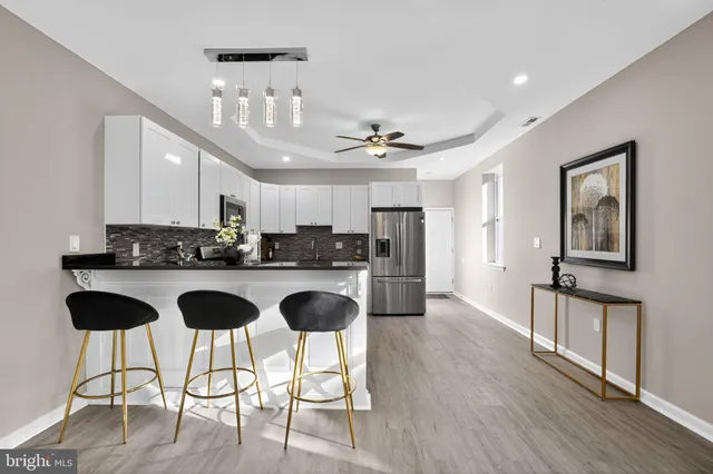 a kitchen with stainless steel appliances granite countertop a refrigerator and a stove top oven