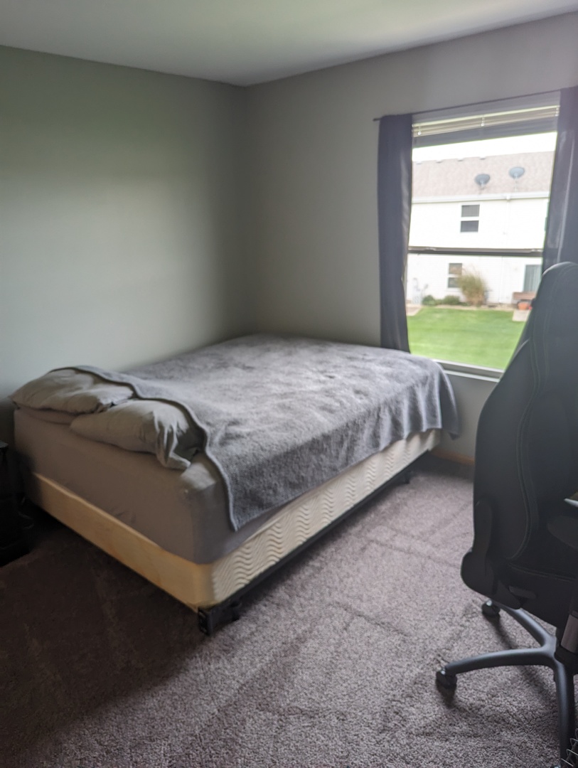 25196 Faraday Road, Unit 1 Manhattan, IL 60442 - Photo 5 of 19 a bed sitting in a bedroom next to a window
