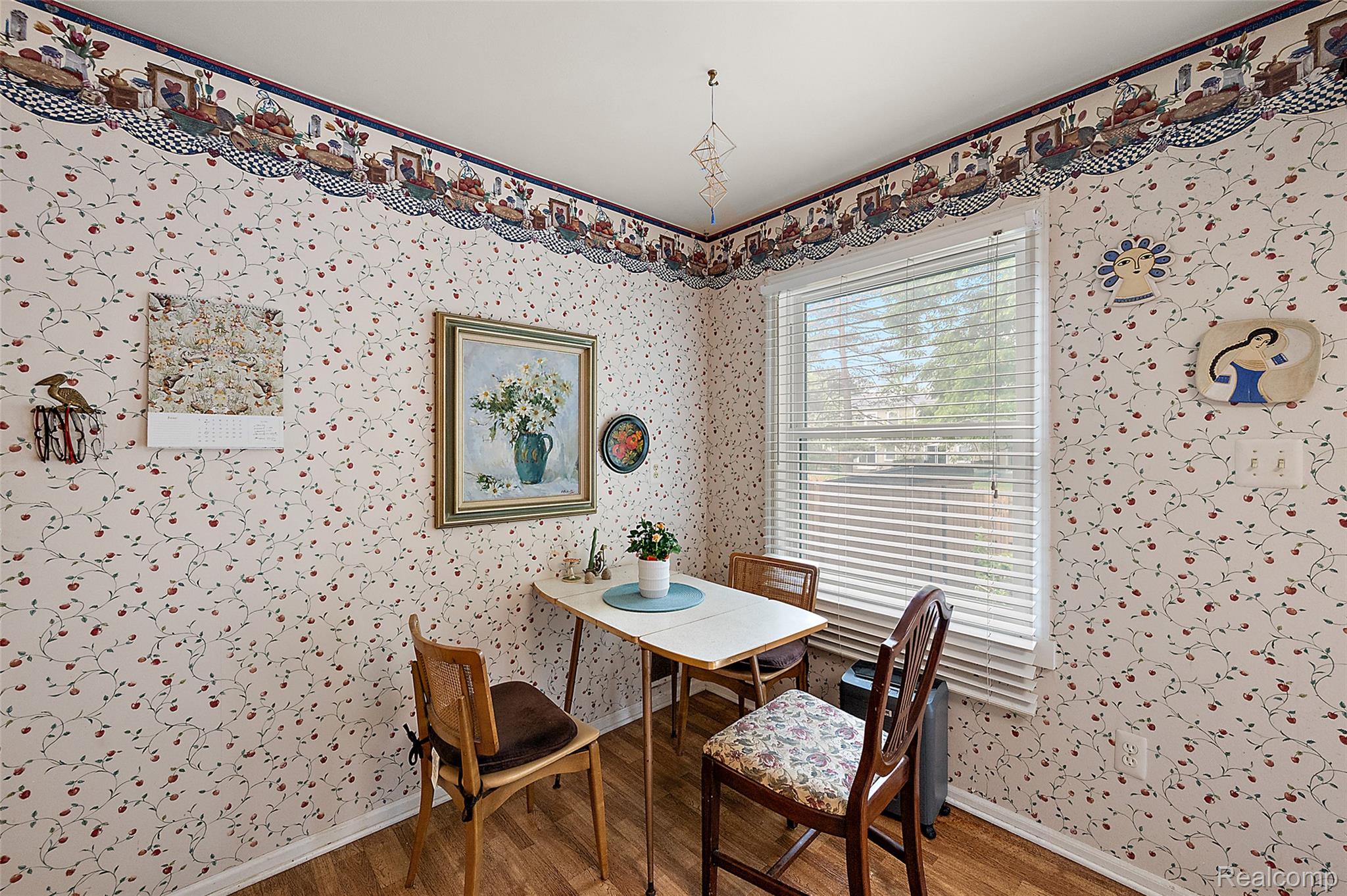930 Little Hill Court Rochester, MI 48307 - Photo 28 of 38 Dining area featuring wood-finish flooring, a large window with horizontal blinds, and decorative wallpaper with a border trim