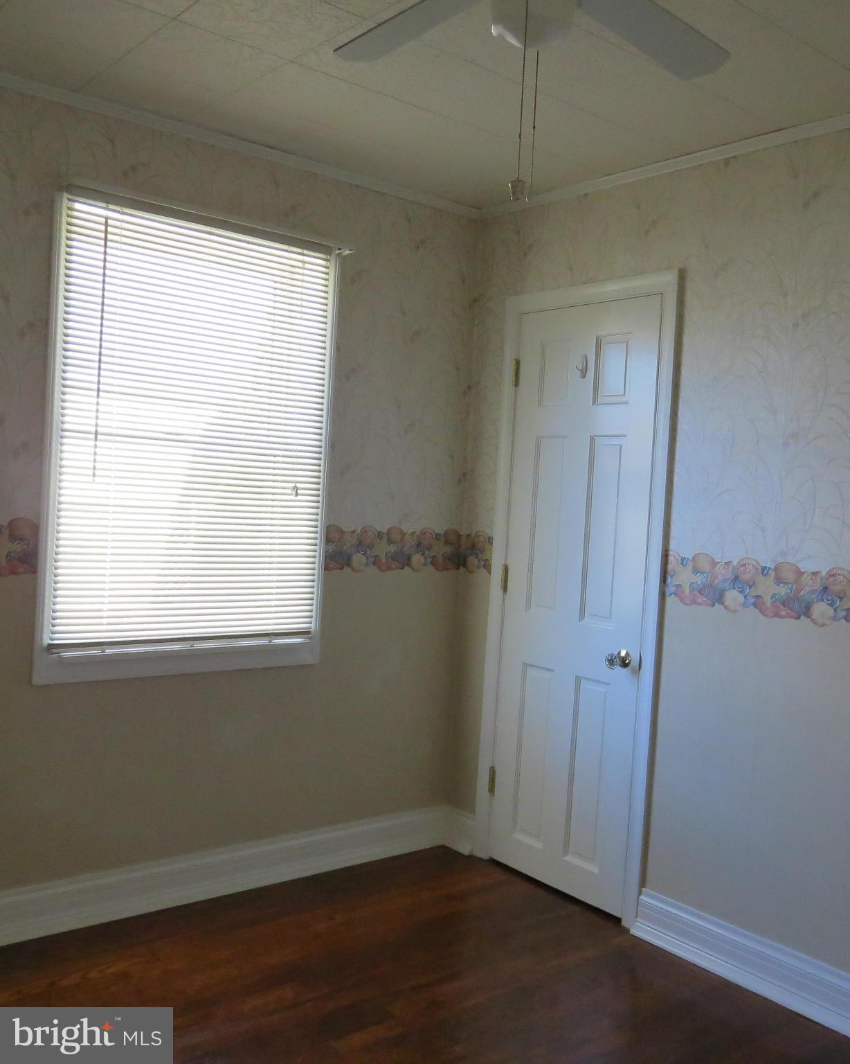 3401 Sollers Point Road Baltimore, MD 21222 - Photo 19 of 29 an empty room with wooden floor and windows